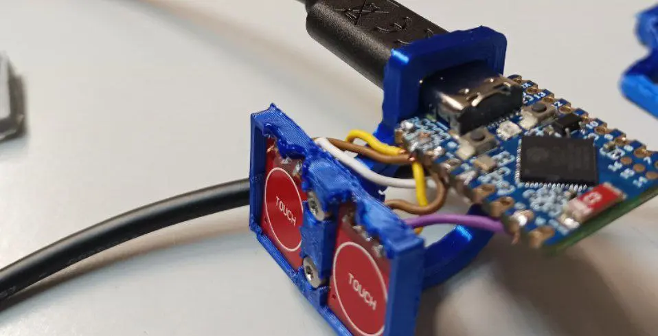 photo of the 3D printed finger ringing, showing the ESP controller unit and two touch buttons